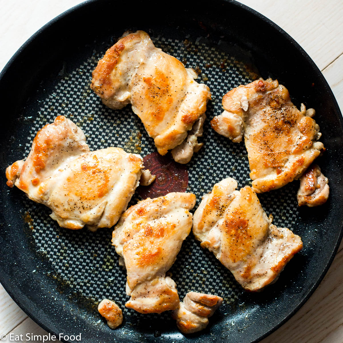 Cooking chicken thighs in a skillet